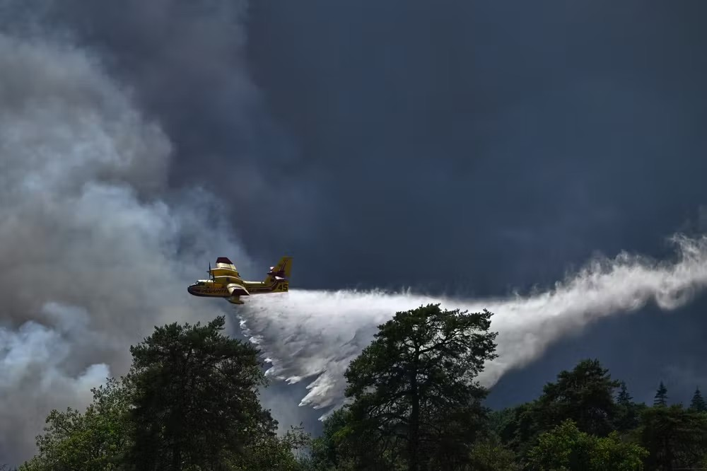 Un Canadair largue de l’eau sur l’incendie qui sévit dans la forêt de Fontainebleau, le 13 juillet 2026. EMMA DA SILVA/AP